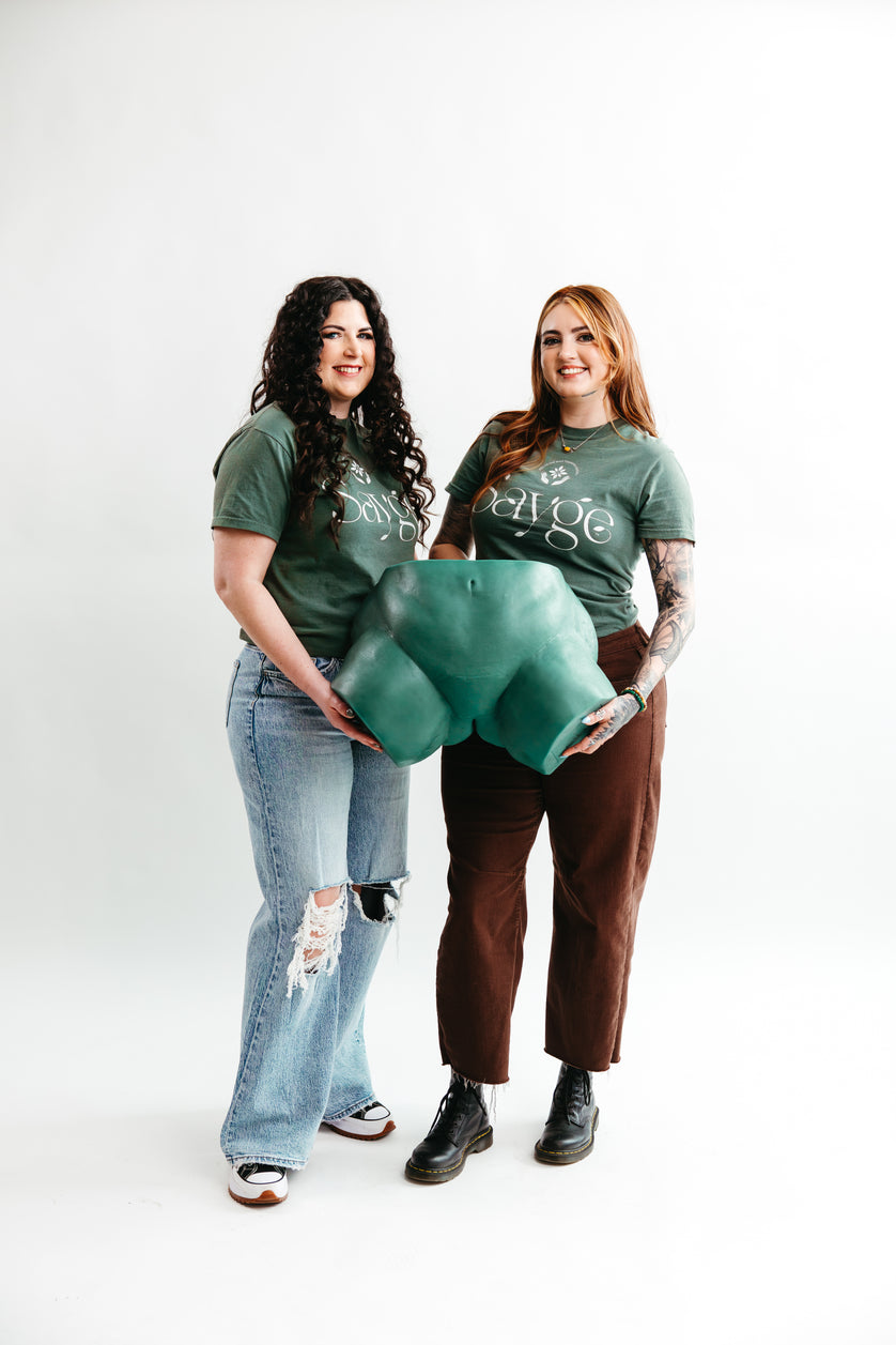 Sayge founders Cadie and Alyssa posing with the Sayge training model on a white backdrop