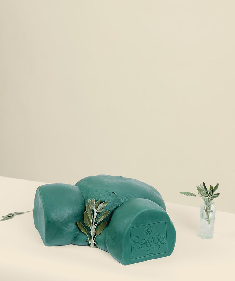 Sayge wax training model with a sage leaf protecting their modesty on a beige background